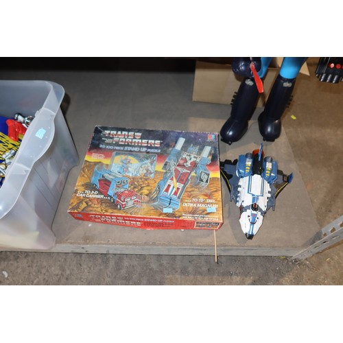 2102 - A quantity of various Transformer related items including toys, DVDs and a 3D 100 piece stand up puz... 