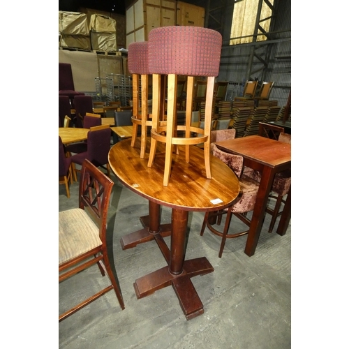 1332 - A tall oval 150cm wooden restaurant/pub type table with 2 upholstered tall dining stools