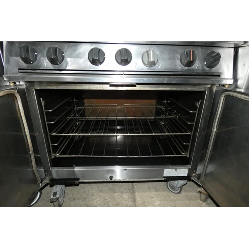 1211 - A gas fired 6 burner range with 2 door oven beneath and shelf above, by Falcon - trade