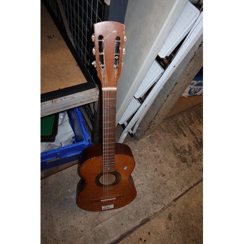 2470 - A small acoustic guitar with soft carry case, no make or model visible