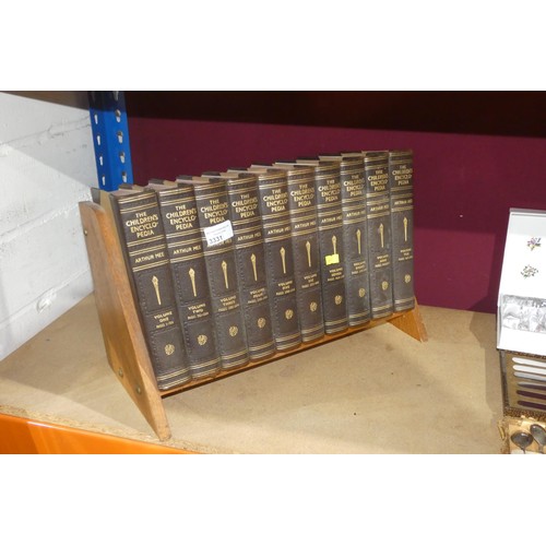 A vintage Oak book rack containing 10 volumes of the Children's ...