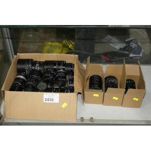 2430 - A quantity of approximately 275 various size and brand camera filters, contents of 4 boxes