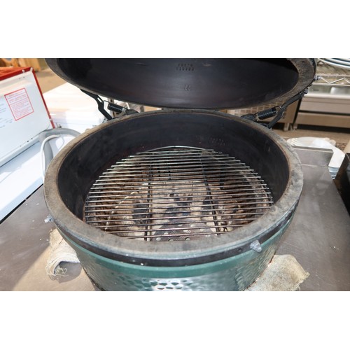 1213 - A commercial Big Green Egg Barbecue custom fitted into a stainless steel catering type table with sh... 