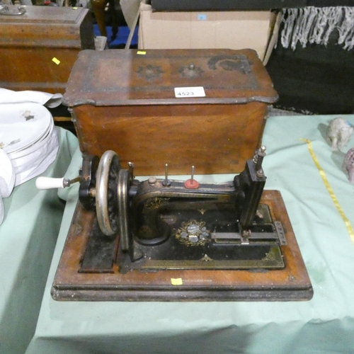 A decorative vintage hand sewing machine with wooden carry case