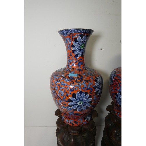 3216 - A pair of blue and red floral patterned vases by Chung with two heavy decorative wooden bases