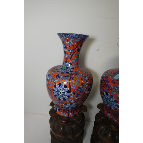 3216 - A pair of blue and red floral patterned vases by Chung with two heavy decorative wooden bases