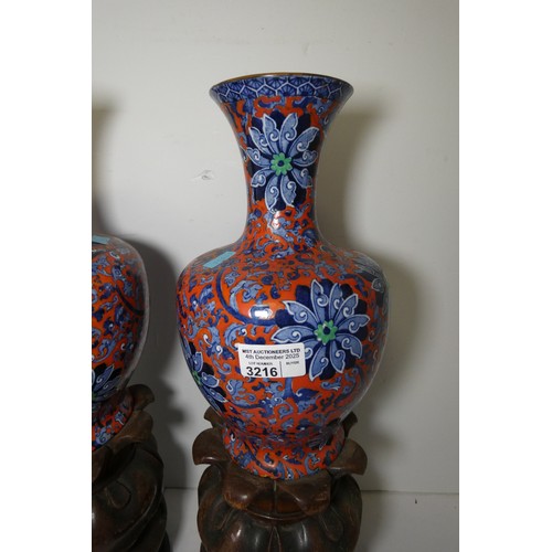 3216 - A pair of blue and red floral patterned vases by Chung with two heavy decorative wooden bases