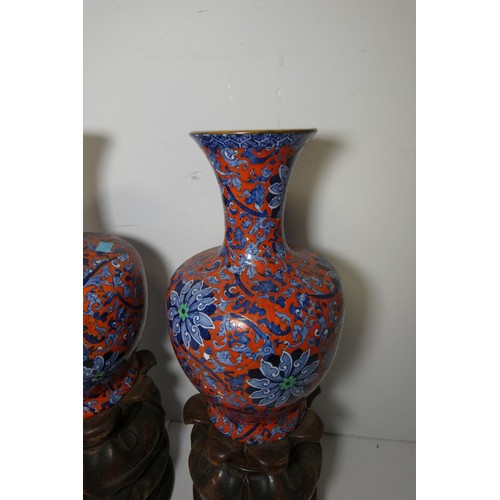 3216 - A pair of blue and red floral patterned vases by Chung with two heavy decorative wooden bases