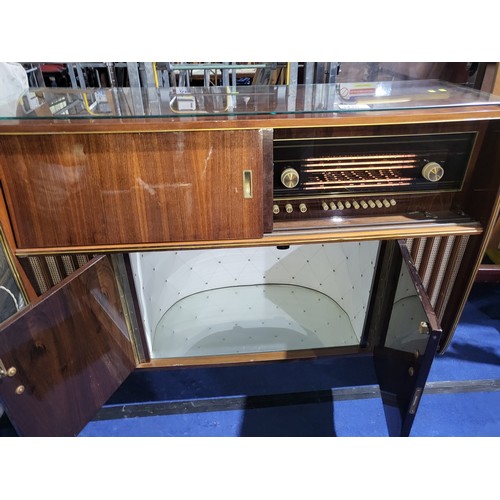 3410 - A 1960s vintage wooden cased radiogram/cocktail cabinet with sliding doors enclosing record  playing... 