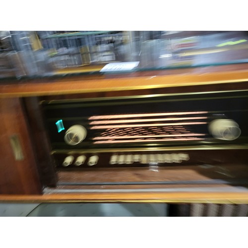 3410 - A 1960s vintage wooden cased radiogram/cocktail cabinet with sliding doors enclosing record  playing... 