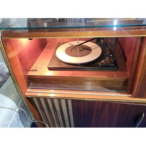 3410 - A 1960s vintage wooden cased radiogram/cocktail cabinet with sliding doors enclosing record  playing... 