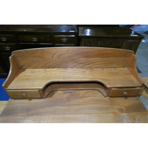 7391 - A mid 20th century Ercol blonde wood small writing desk with two trinket drawers, one drawer below a... 