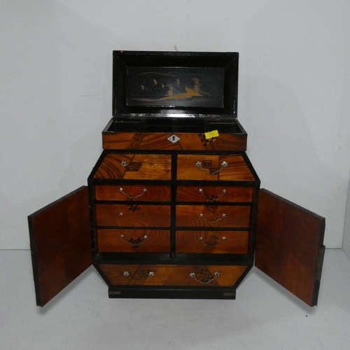 7552 - A miniature table top oriental cabinet with two doors enclosing small drawers