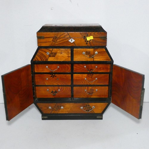7552 - A miniature table top oriental cabinet with two doors enclosing small drawers