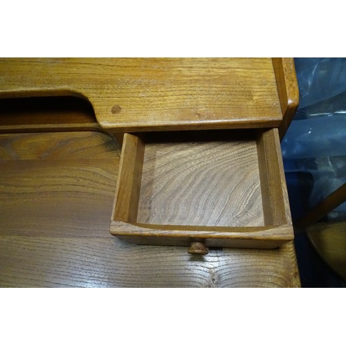 7391 - A mid 20th century Ercol blonde wood small writing desk with two trinket drawers, one drawer below a... 