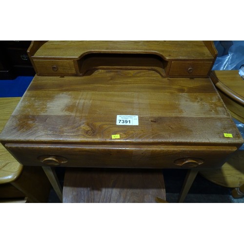 7391 - A mid 20th century Ercol blonde wood small writing desk with two trinket drawers, one drawer below a... 