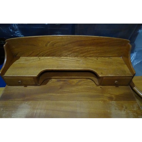 7391 - A mid 20th century Ercol blonde wood small writing desk with two trinket drawers, one drawer below a... 