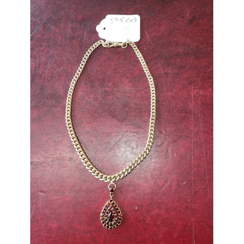 4211 - A 9 ct. yellow gold neck chain with pear shaped garnet pendant, approximately 36cms long, weight app... 