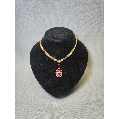 4211 - A 9 ct. yellow gold neck chain with pear shaped garnet pendant, approximately 36cms long, weight app... 