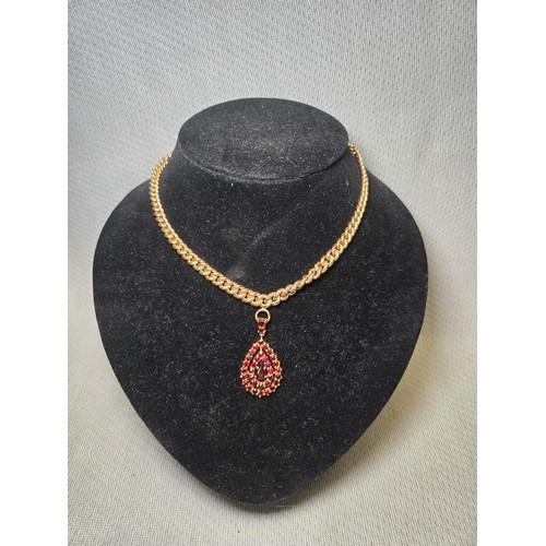 4211 - A 9 ct. yellow gold neck chain with pear shaped garnet pendant, approximately 36cms long, weight app... 