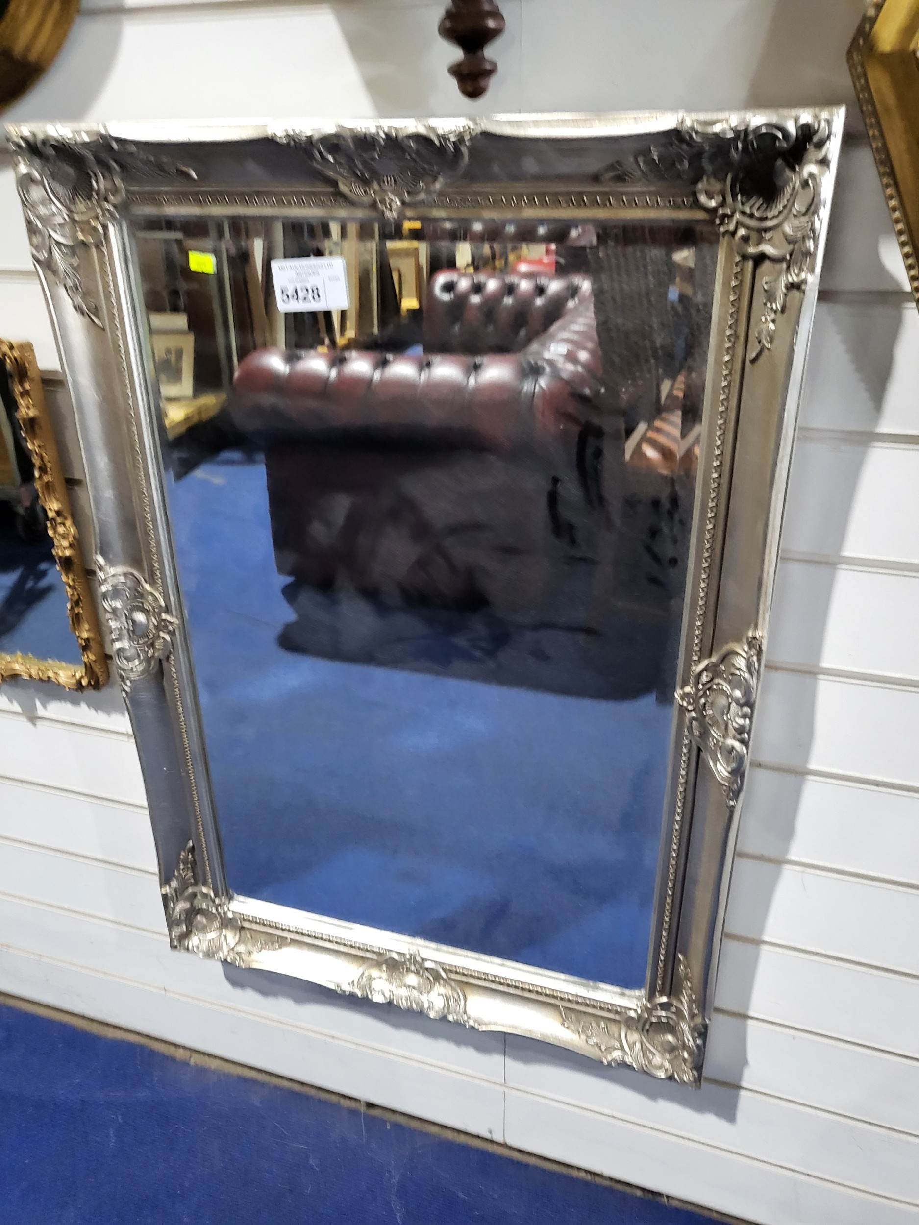 A Vintage silvered rectangular rococo style mirror with bevelled plate.