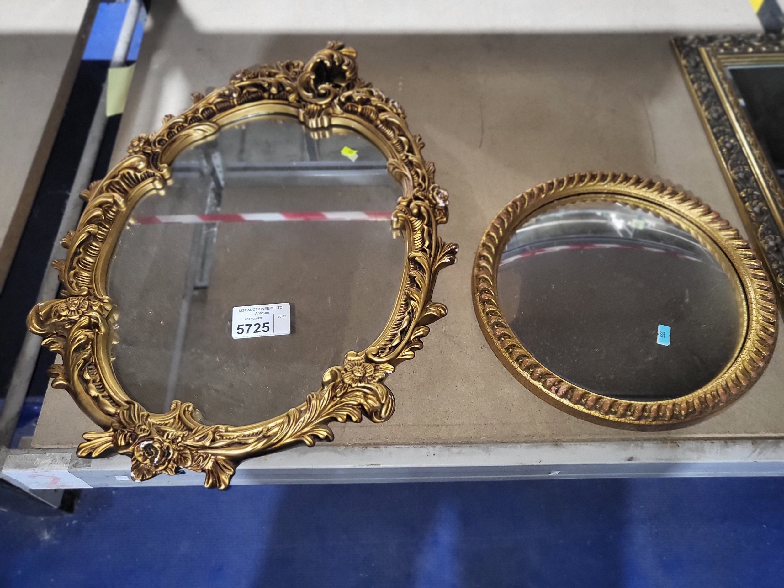An oval wall mirror with decorative gilt work frame and a small ...