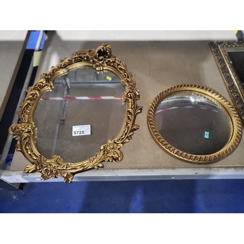 An oval wall mirror with decorative gilt work frame and a small ...