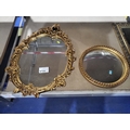 An oval wall mirror with decorative gilt work frame and a small ...