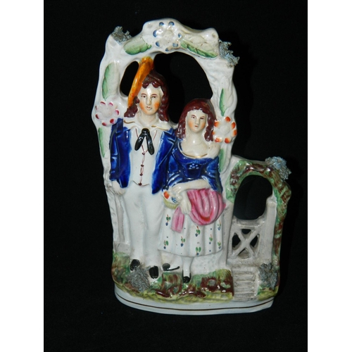 11 - Staffordshire pottery 'Courting Couple' standing in archway and Staffordshire flatback couple