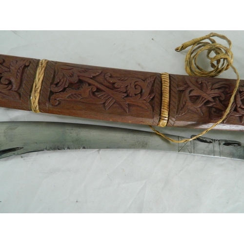 128 - Dayak mandu headhunters sword or terbang of typical form with shagreen grip and carved scabbard. Bla... 