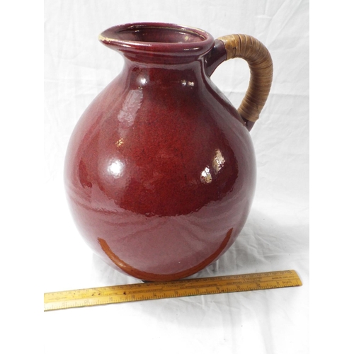 224 - Stoneware jug with cane wrapped handle