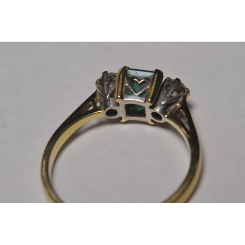 113 - 18ct gold engagement ring set with table cut emerald flanked by twin diamonds, stamped 750, hallmark... 