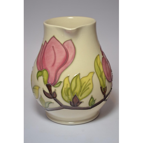 70 - Moorcroft pottery jug having pink magnolia design on cream ground approx 14.5 cm high.