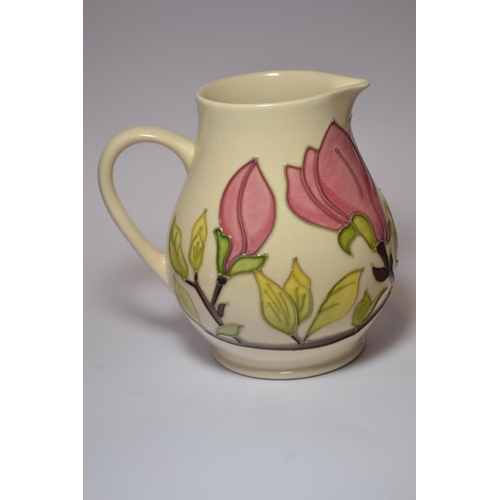 70 - Moorcroft pottery jug having pink magnolia design on cream ground approx 14.5 cm high.