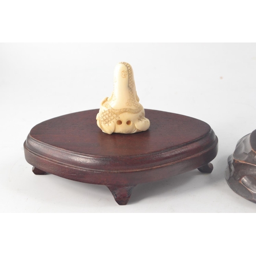 79 - 2 Chinese carved bone Netsukes in the form of Shou Lao with 2 wooden bases