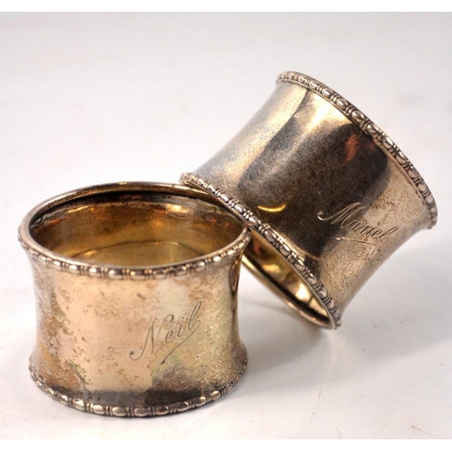 42 - 2 silver napkin rings 'Muriel and Neil' inscribed with reed edge and concave egg shape Birmingham 19... 