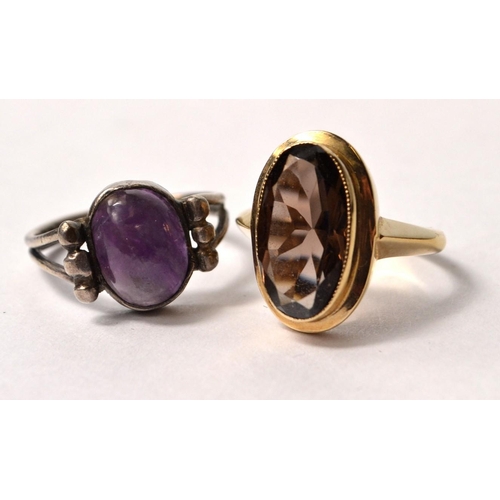 9 - Two rings, 1 oval set purplish stone 375 hallmarked size M and 1 white metal oval purple set stone s... 