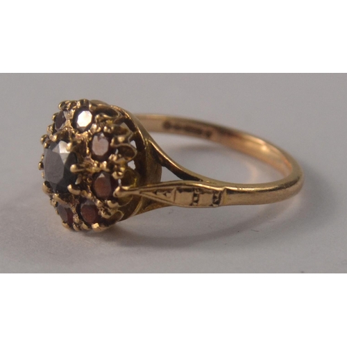 31 - A 9ct gold floral garnet cluster set ring, with 9 garnets size O