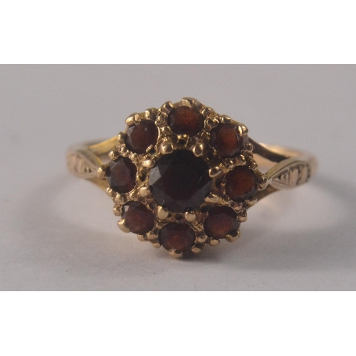 31 - A 9ct gold floral garnet cluster set ring, with 9 garnets size O