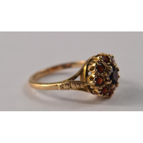 31 - A 9ct gold floral garnet cluster set ring, with 9 garnets size O