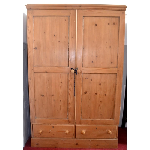 409 - Vintage pine wardrobe with inset panel doors above two short drawers