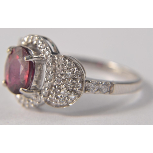 43 - 18 carat Birmingham white gold ruby and diamond ring. Size O. Set with oval ruby (L 8mm x W 5mm), en... 