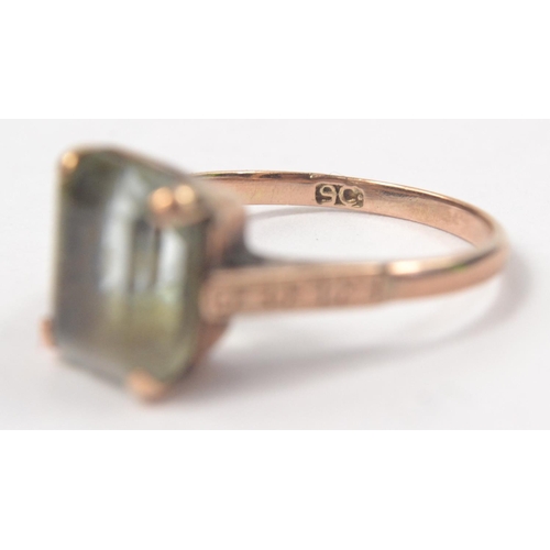 64 - 9ct Rectangular pale green stone set ring. Shoulders with o and x design. Size N