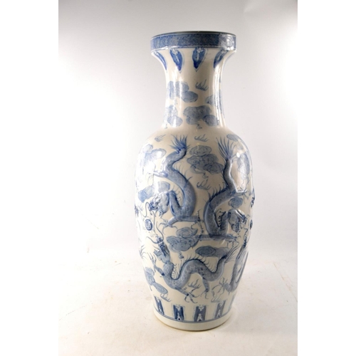 110 - Large oriental blue and white Roleau vase with dragon design