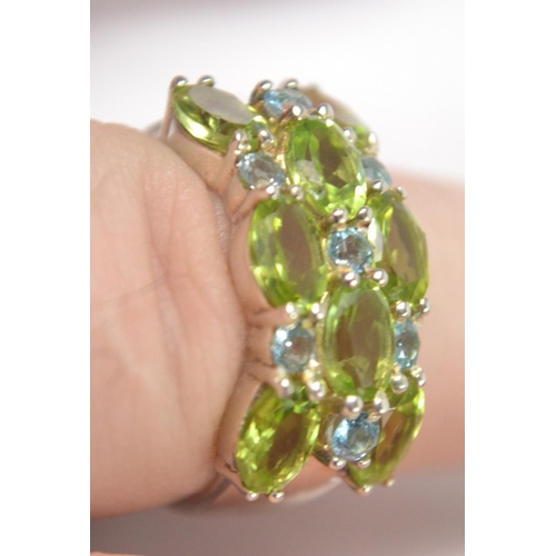 41 - 925 Silver stamped ring, set with 8 pale green stones with 7 very pale blue stone spacers Size P