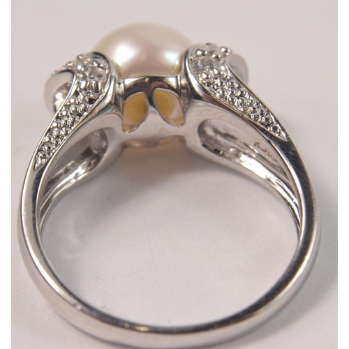 45 - 925 Silver stamped ring set with central pearl style stone and clear stone shoulders Size Q