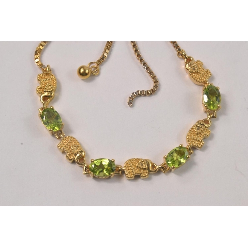 47 - Yellow metal bracelet set with 4 pale green stones seperated by 5 small yellow metal elephants. [7.6... 