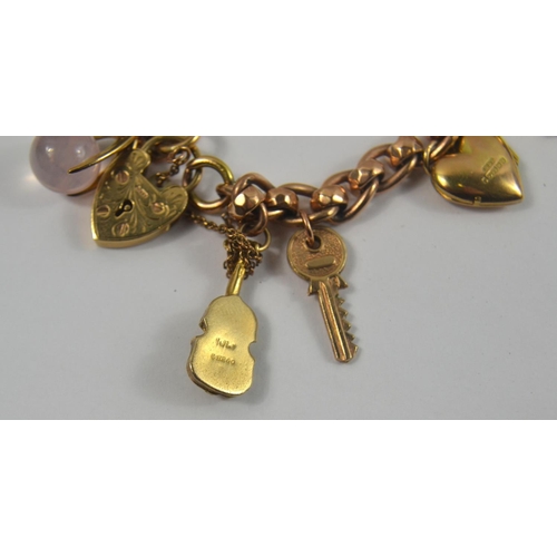 160 - A nice gold charm bracelet, filled with charms. Chain is 375 stamped gold with 12 charms, one a moun... 