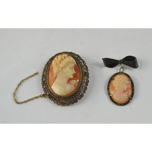 40 - A pair of vintage Cameo brooches, largest 15.5g gross and 5 cm length and smaller Victorian white me... 