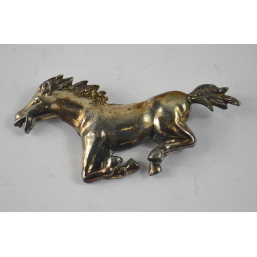 43 - From a marvellous collection of jewellery A white metal quality galloping horse with makers marks ... 